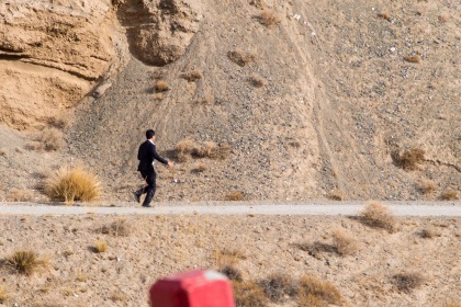 A Chinese businessman chasing an ibex for a photo